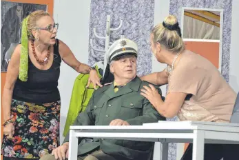  ??  ?? Elfie (Ruth Scheffold) und Susi (Sibylle Seifert) umgarnen den Polizisten Singer (Franz Wolfmaier). Kundin Frau Rasch (Isolde Romer) überwacht das Geschehen vom Schrank aus.