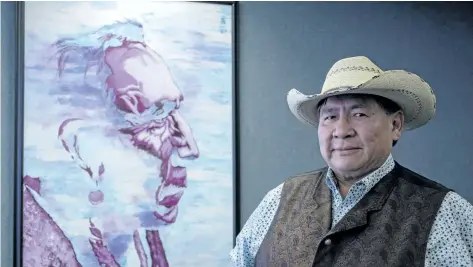  ?? JEFF MCINTOSH/ THE CANADIAN PRESS ?? Tsuut’ina Chief Lee Crowchild stands in front of a painting of a Tsuut’ina elder at his office in Calgary.