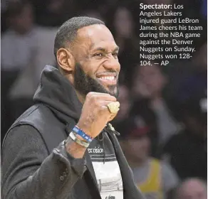  ?? — aP ?? Spectator: Los angeles Lakers injured guard Lebron James cheers his team during the Nba game against the denver Nuggets on sunday. Nuggets won 128104.