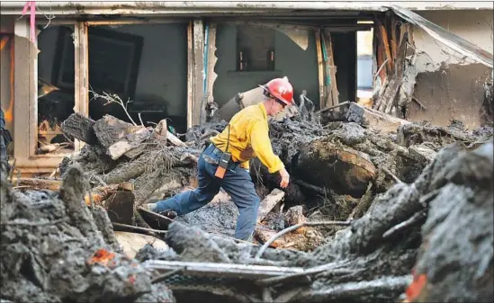  ?? Photograph­s by Al Seib Los Angeles Times ?? FIREFIGHTE­RS work to clear debris from a home on Olive Mill Road in Montecito on Thursday after search dogs alerted to a possible body buried in the muck.