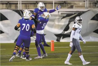  ?? Photos by John Locher / Associated Press ?? San Jose State running back Tyler Nevens is lifted by teammates after scoring against Nevada during the second half in Las Vegas. The Spartans outscored Nevada 230 after halftime.