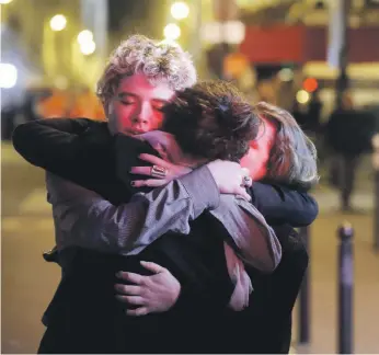  ?? Reuters; AFP ?? People hug on the street near the Bataclan concert hall following the terrorist attacks in Paris on November 14, 2015, in which 130 people were killed when by 10 ISIL extremists. Left: Jawad Bendaoud, the man who allegedly lent his apartment in a Paris...