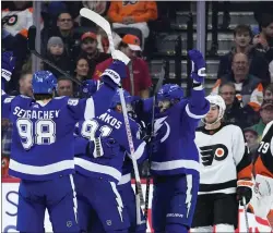  ?? MATT SLOCUM — THE ASSOCIATED PRESS ?? Tampa Bay Lightning’s Steven Stamkos (91) celebrates with teammates after getting an assist on a goal by Nicholas Paul during the second period Thursday night at Wells Fargo Center. Looking on are Flyers’ Tony DeAngelo and Carter Hart, right.