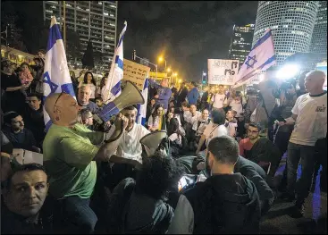  ?? — THE ASSOCIATED PRESS ?? Israeli protesters hold flags and chant slogans during a demonstrat­ion in Tel Aviv yesterday against the ceasefire between Israel and Gaza’s Hamas.