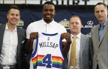  ??  ?? New Nuggets forward Paul Millsap, second from left, holds up his jersey as Josh Kroenke, team president and governor, left, Tim Connelly, president of basketball operations and Arturas Karnisovas, general manager of the Nuggets, join in for a...