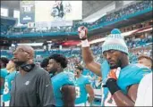  ?? Wilfredo Lee Associated Press ?? MIAMI DOLPHINS defensive end Robert Quinn raises his fist during the national anthem Thursday.