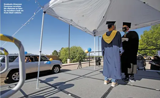  ??  ?? Graduate Aiverson Carmona receives his diploma as family members look on from their vehicle.