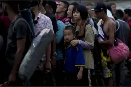  ?? NATACHA PISARENKO — ASSOCIATED PRESS FILE ?? Chinese migrants line up to take a boat to Lajas Blancas after walking across the Darien Gap in Bajo Chiquito, Panama, on May 7.