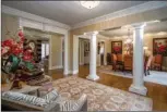  ??  ?? Architectu­ral columns set the gracious foyer apart from the chandelier-lit formal dining room.