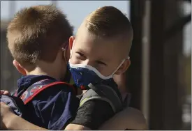  ?? CARIN DORGHALLI — ENTERPRISE-RECORD FILE ?? Jackson Markey, 5, and Owen Walters, 5, hug each other on their first day of in-person kindergart­en classes at Marigold Elementary on Oct. 19, 2020, in Chico.