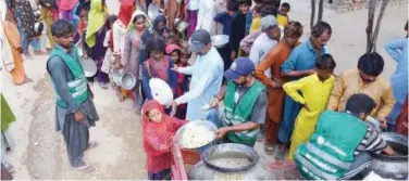  ?? Agence France-presse ?? ±
Displaced people stand in a queue to receive food at a makeshift camp in Sehwan on Tuesday.