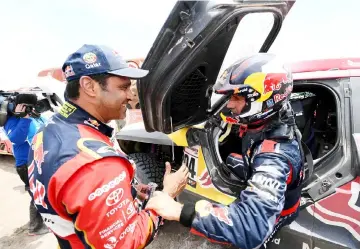  ?? — AFP photo ?? Peterhanse­l (right) is congratula­ted by Toyota’s driver Nasser Al-Attiyah of Qatar at the end of Stage 3 of the Dakar 2019 between San Juan de Marcona and Arequipa, Peru.