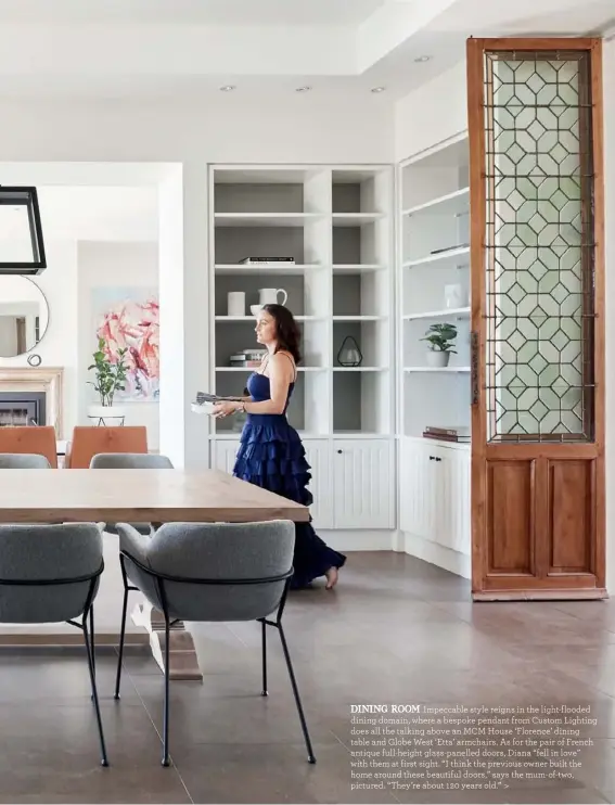  ??  ?? DINING ROOM Impeccable style reigns in the light-flooded dining domain, where a bespoke pendant from Custom Lighting does all the talking above an MCM House ‘Florence’ dining table and Globe West ‘Etta’ armchairs. As for the pair of French antique full-height glass-panelled doors, Diana “fell in love” with them at first sight. “I think the previous owner built the home around these beautiful doors,” says the mum-of-two, pictured. “They’re about 120 years old.” >