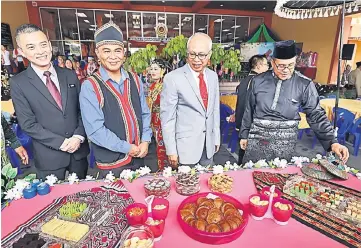  ??  ?? Syafiq (right), Mansor (second right) and others pose at a stall offering an assortment of desserts. — Photo by Chimon Upon