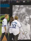  ?? The Canadian Press ?? Brandy Halladay and her two sons Ryan Halladay, left, and Braden Halladay walk onto the field for a ceremony for their late father Roy Halladay prior to the Toronto Blue Jays’ opening-day game.