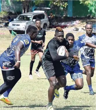  ?? KAVARLY ARNOLD ?? Kareem Harris of Young Crocs (centre) trying to evade the tackles of Mona Titans Rajiv Haughton (right) and Nathan Campbell in the MoBay Sun Splash Sevens Rugby Tournament at Jarrett Park on Saturday. Titans won 26-5.