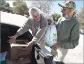  ?? Dan Watson/The Signal ?? Santa Clarita Veterans Services Collaborat­ive volunteer Steve Ends, left, assists U.S. Army veteran Ed Atkins as he loads a donated turkey and holiday side dishes into his trunk during the Turkeys for Veterans event held at VFW Post 6885 in Canyon Country on Saturday.