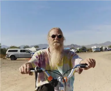  ?? JAKE MICHAELS PHOTOS/THE NEW YORK TIMES ?? A Rubber Tramp Rendezvous attendee gets around via bicycle, in Quartzite, Ariz.