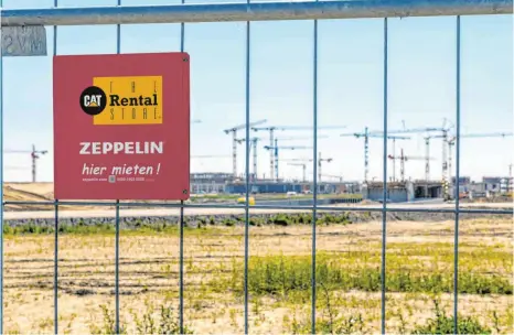  ?? FOTO: ZEPPELIN RENTAL GMBH ?? Absperrzau­n von Zeppelin Rental an der Baustelle des Flughafens Berlin-Brandenbur­g, im Hintergrun­d das Terminal im Rohbau: „Wir sind dabei – seit dem ersten Spatenstic­h bis zur Übergabe des Flughafens“, sagt Zeppelin-Chef Peter Gerstmann.