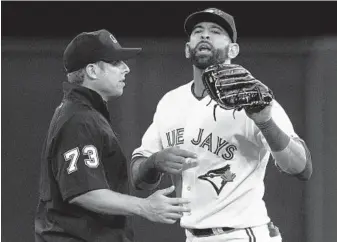  ?? CHRIS YOUNG/CANADIAN PRESS ?? The Blue Jays’ Jose Bautista is restrained by umpire Tripp Gibson as he shouts to the Orioles bench while taking the field for the eighth inning. Bautista was angry that a pitch from the Orioles’ Jason Garcia came close to him.