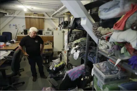  ?? MARCIO JOSE SANCHEZ — THE ASSOCIATED PRESS ?? Terry Schoop, community services department manager for Burning Man festival, looks through some lost and found items at the organizati­on’s headquarte­rs in San Francisco. Unclaimed items are listed on Burning Man’s official website with photos and lot...