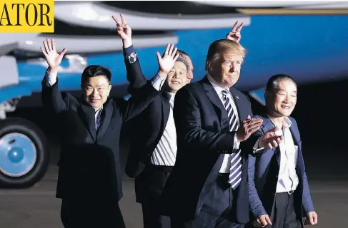  ?? ALEX BRANDON / THE ASSOCIATED PRESS ?? U.S. President Donald Trump walks with former North Korean detainees Tony Kim, Kim Hak-song and Kim Dong-chul at Andrews Air Force Base, Md.