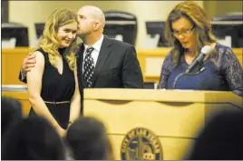  ?? Erik Verduzco ?? Las Vegas Review-journal @Erik_verduzco Graduate Sarah Hawk, left, is kissed by father Mike as mother Chris gives a speech during the Youth Offender Court graduation Thursday at Las Vegas City Hall.