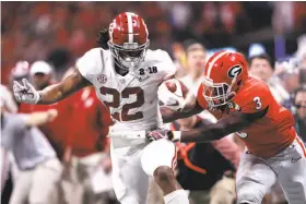  ?? Jamie Squire / Getty Images ?? Alabama’s Najee Harris gains yardage on a second-half run despite the efforts of Georgia’s Roquan Smith. Harris rushed for 64 yards on six carries.