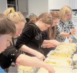  ?? ?? Youngsters including those from Maidenhead’s Ukrainian community making 100 meals for Maidenhead Foodshare.