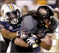  ?? AP/DAVE MARTIN ?? Arkansas State quarterbac­k Adam Kennedy (5) is pursued by Auburn’s Ben Bradley (50) as he looks for a receiver in the first half of Auburn’s 38-9 victory Saturday in Auburn, Ala.