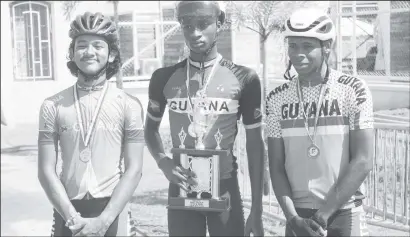  ?? (Emmerson Campbell photo) ?? Winners Row! Guyana’s Sherwin Sampson (Centre) Alex Leung (left) and Aaron Newton pose for a photo with Team Guyana’s first place trophy for the discipline of cycling.