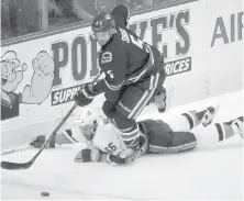  ?? JONATHAN HAYWARD, THE CANADIAN PRESS ?? Canucks defenceman Luca Sbisa avoids the check from a sprawling Islanders centre Joshua Ho-Sang during the second period in Vancouver on Thursday.