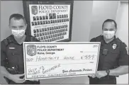  ?? Floyd County Police Department ?? Floyd County police officers Baker Harbin (left) and Carlos Ribot hold up a blank check for the department’s annual fundraiser. Last year the FCPD golf tournament raised more than $10,000 for Elevation House, an advocate for mental health that helps clients enter the local workforce.