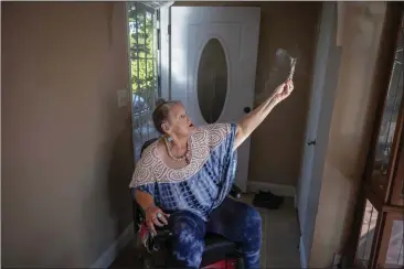  ?? PHOTO BY RAHUL LAL FOR CALMATTERS ?? Bonnie Metcalf lights sage during her morning routine at her Sacramento home on July 20, 2023. Metcalf spreads the smoke to entrance and exit points to clear negative energy and promote relaxation.