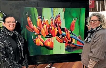  ?? STUFF ?? Riversdale Arts exhibition administra­tor Jann Robertson, left, and president Kerryn Miller check out a painting of flax flowers ahead of the organisati­on’s opening night of its mixed media exhibition today.