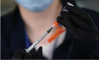  ?? NAncy LAnE / HErALd StAFF ?? MINIMAL LOSSES: Philippa Edwards, EMT-B, loads a syringe with a COVID vaccine outside the Children's Museum on July 20.