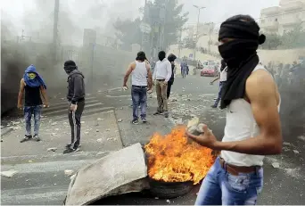  ??  ?? Pietre Giovani palestines­i a Gerusalemm­e Est, dove i disordini sono continuati ieri (Reuters/ Ammar Awad)