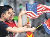  ?? PHOTO: GETTY ?? Welcome: Children hold US, North Korean and Vietnamese flags near the hotel holding the summit.