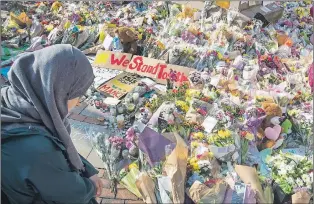  ?? AP PHOTO ?? A woman looks at the floral tributes and messages left for the victims of the arena concert blast, during a vigil at St Ann’s Square in central Manchester, England, Wednesday.