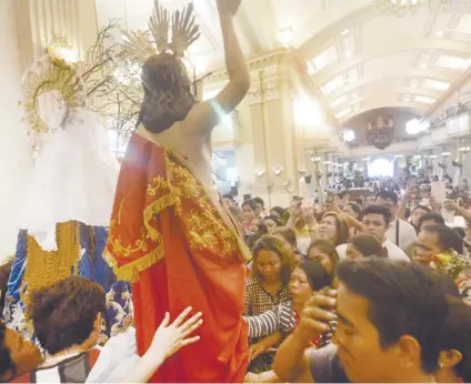  ?? SUNSTAR FOTO / ALLAN CUIZON ?? DEVOTION. The faithful gather to pray before and touch the images of Jesus Christ and the Virgin Mary after the Easter Sunday mass at the Cebu Metropolit­an Cathedral.