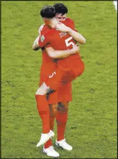  ?? Thanassis Stavrakis The Associated Press ?? England defenders Harry Maguire, left, and John Stones hug at the end of a 2-0 World Cup quarterfin­al victory over Sweden on Saturday in Samara, Russia.