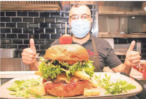  ?? RP-FOTO: RANDORF VASTMANS ?? Ali Patlar präsentier­t hier in seinem Imbiss-Restaurant Irem in Alpen einen Bacon-Burger mit Spargelstü­cken.
