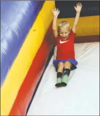  ?? The Sentinel-Record/Grace Brown ?? SUMMER FUN: Carter Smith, 4, of Hot Springs, slides down an inflatable slide at Spa Blast in the infield of Oaklawn Racing Casino Resort July 3. The Independen­ce Day holiday falling during the middle of the week didn’t deter visitors from making a long weekend trip to Hot Springs, according to local tourism officials.