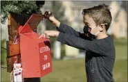  ??  ?? Park Parsons, 6, checks the mailbox for Letters to Santa at his family’s home in Exeter Township.