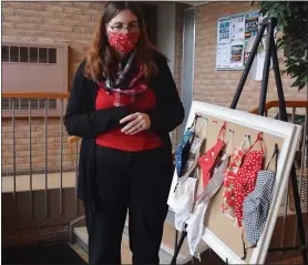  ?? NATALIE BRODA — MEDIANEWS GROUP ?? Laura Kelsey, pastor at the First Presbyteri­an Church of Pontiac, stands beside a board with free face masks pinned to it at the entrance of the church.