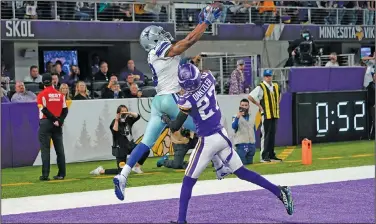  ?? Associated Press ?? In for six: Dallas Cowboys wide receiver Amari Cooper (19) catches a 5-yard touchdown pass over Minnesota Vikings cornerback Cameron Dantzler (27) during the second half of an NFL football game Sunday in Minneapoli­s.