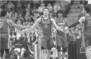  ?? CHARLIE NEIBERGALL/ AP ?? Keyontae Johnson, celebratin­g with Florida teammates in the NCAA Tournament in 2019, is helping the coaching staff in practice.