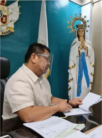  ?? (Chris Navarro) ?? WORKING ON MAMA MARY'S DAY. Bacolor Mayor Eduardo 'Diman' Datu is busy signing documents as he joined the whole Christian community in commemorat­ing yesterday the birth of the Blessed Virgin Mary.