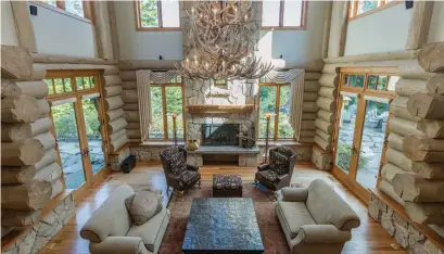  ?? SOTHEBY’S INTERNATIO­NAL REALTY CANADA PHOTOS ?? The great room, with Douglas fir log walls, features a cathedral ceiling set off by a chandelier of broken antlers found in the woods.