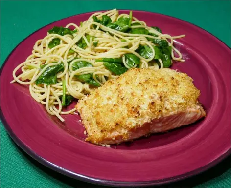  ?? Linda Gassenheim­er / Tns ?? Try out Parmesan-crusted salmon with spaghetti and spinach.